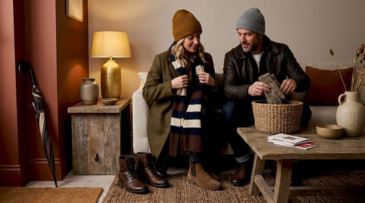 Couple removing winter accessories in entryway