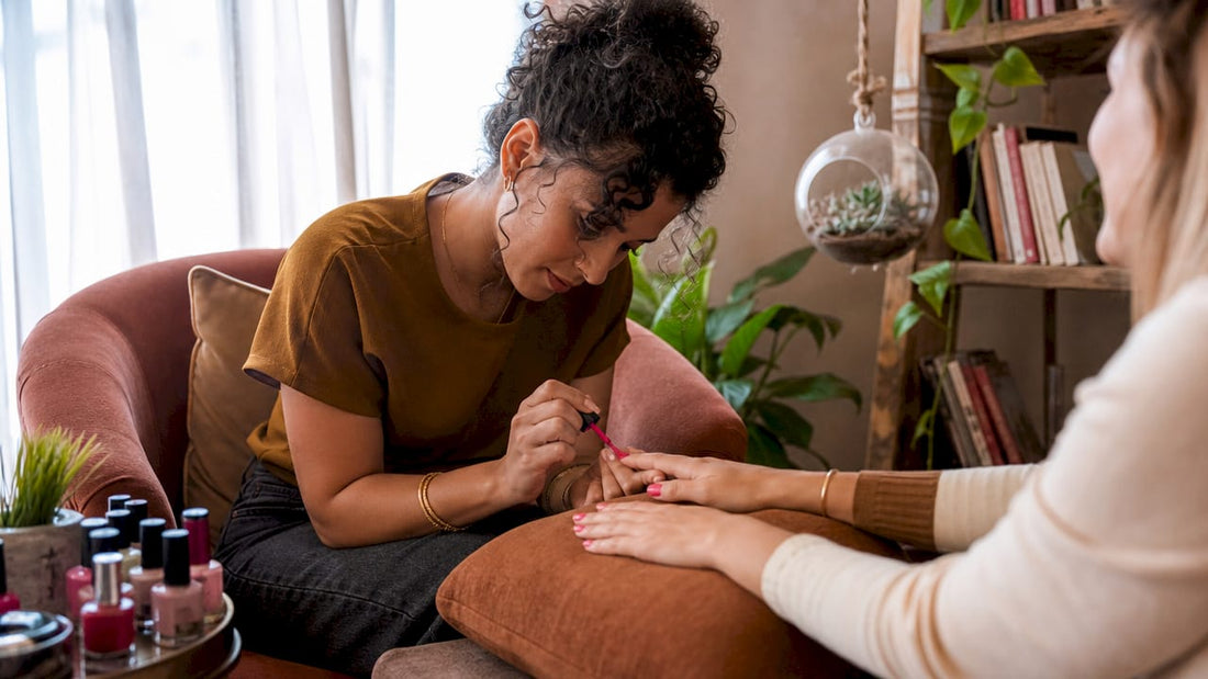 Manicurist applying bold cobalt blue nail polish