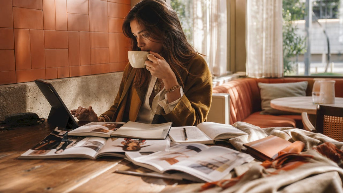 Woman browsing online fashion store on tablet at kitchen table