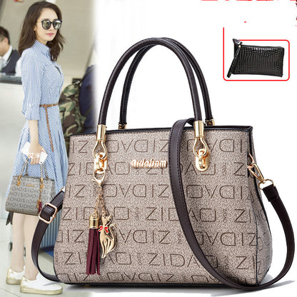 Stylish woman with large designer handbag, patterned with gold hardware and tassel charm