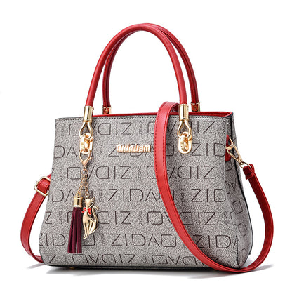 Gray and red ZIDAM handbag with gold hardware and cat tassel charm