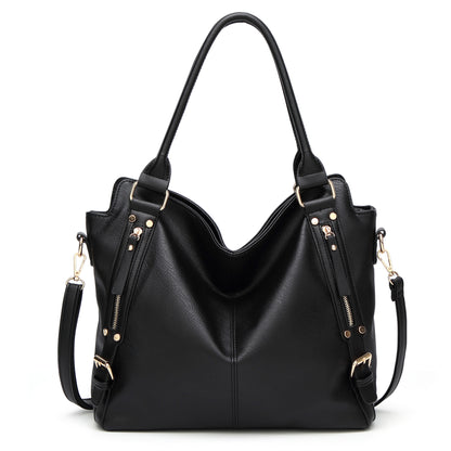 Black leather tote bag with gold hardware, top handles, and zipper accents on a white background.