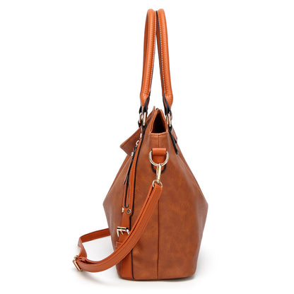 Side view of brown leather tote bag with double handles and detachable strap