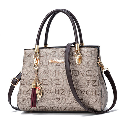 Stylish beige designer handbag with gold hardware, cat charm, and ZIDA logo pattern