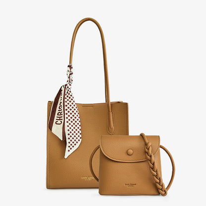 Tan leather tote bag with polka dot scarf and small crossbody purse, on white background