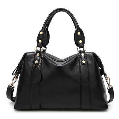 Black leather handbag with gold hardware, dual handles, and detachable strap on white background.