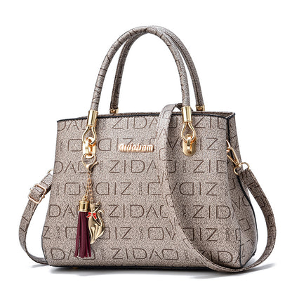 Beige designer handbag with gold hardware, cat charm, and embossed ZIDAI pattern