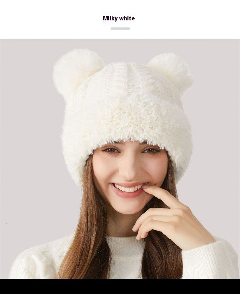 Woman smiling in a milky white knit hat with bear ears, cozy winter fashion accessory